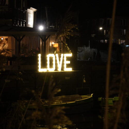 LOVE-lichtletters buiten opgesteld op een donkere trouwlocatie